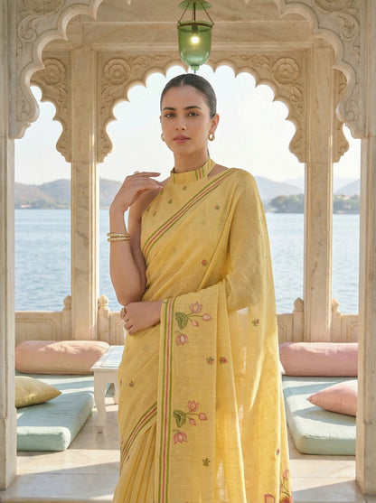 Woman in a yellow saree with floral patterns standing in front of a scenic view. Yellow Pichwai Jamdani Cotton Saree for women